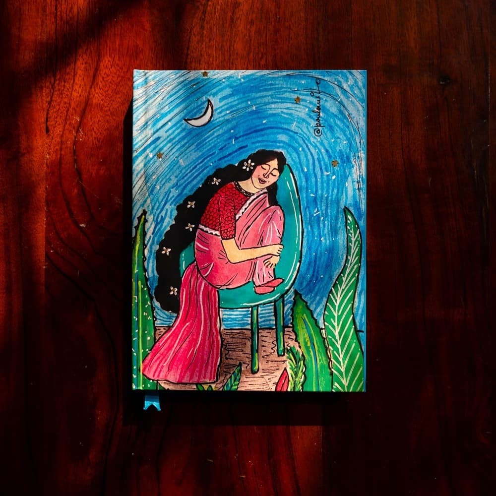 An illustrated journal photographed on a dark wood surface