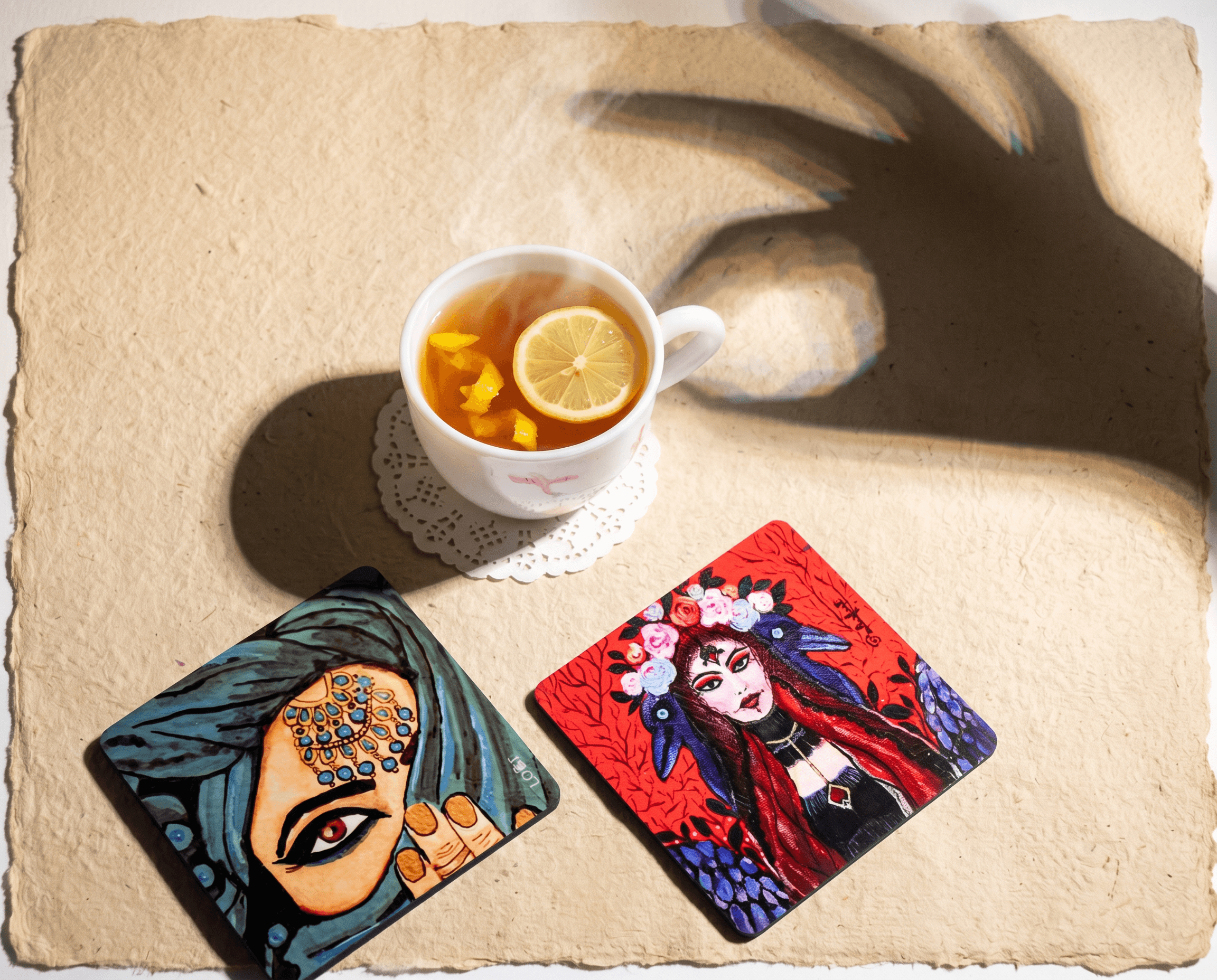 Illustrated coasters styled beside a cup of lemon tea on textured handmade paper