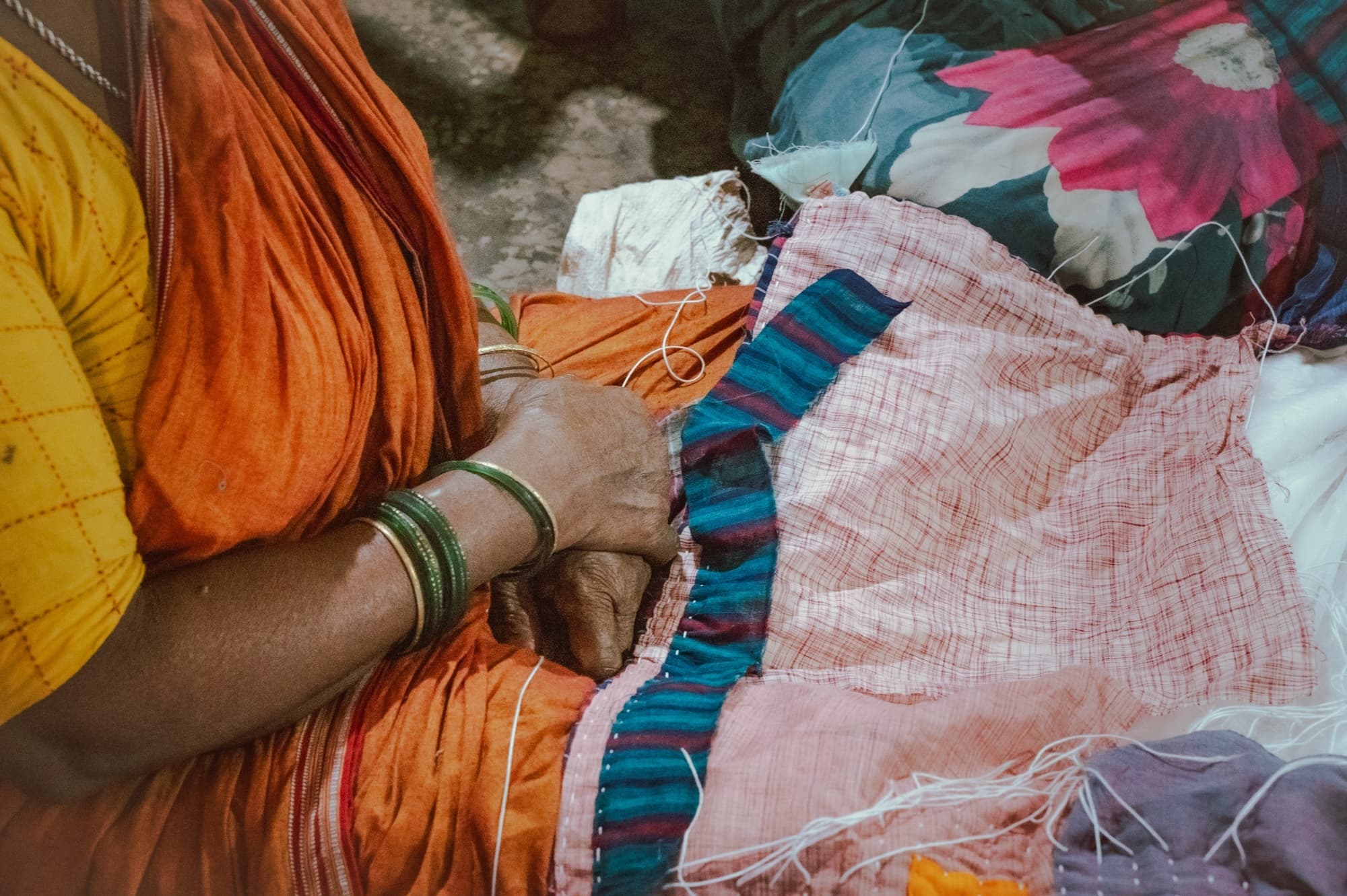 Close-up of hands cutting and piecing together fabric for a quilt